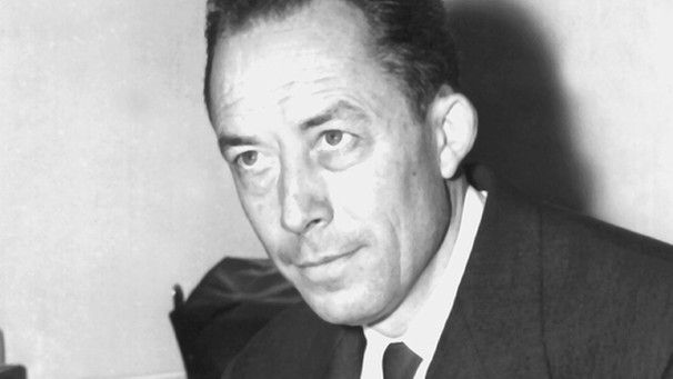 Albert Camus nach der Vergabe des Nobelpreises mit einigen seiner Bücher | Bild: picture-alliance/dpa