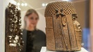 Eine Museumsbesucherin betrachtet Raubkunst-Bronzen aus Benin in Westafrika 2018 im Hamburger Museum für Kunst und Gewerbe  | Bild: picture alliance / Daniel Bockwoldt/dpa