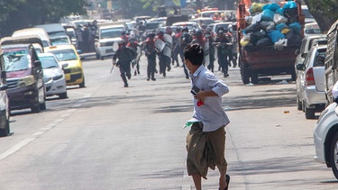 Archivbild: Myanmar, Rangun: Bereitschaftspolizisten rennen einem Demonstranten nach. Myanmars Polizei feuerte bei den heutigen Protesten neben Gummigeschossen auch echte Munition und setzte Tränengas und Schallbomben gegen die Anti-Putsch-Demonstranten ein. Mehere Demonstranten wurden festgenommen, darunter 4 Journalisten. Eine Frau wurde während eines Protestes in der Stadt Monywa in der Nähe von Mandalay erschossen. | Bild: dpa-Bildfunk/Santosh Krl