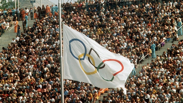 Auf Halbmast geflaggt ist die Olympische Fahne während der Trauerfeier am 06.09.1972 im Münchner Olympiastadion für die Opfer eines palästinensischen Terroranschlages auf die israelische Olympia-Mannschaft. | Bild: picture-alliance/dpa
