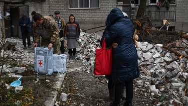 Ukraine, Tschassiw Jar: Anwohner stehen nach einem Luftangriff in der Nähe eines zerstörten Hauses Ende November 2022 | Bild: dpa-Bildfunk/Andriy Andriyenko