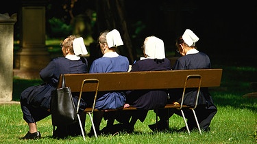 Vier Diakonisse sitzen auf einer Bank (Aufnahme von hinten) | Bild: picture-alliance_Oswald Eckstein