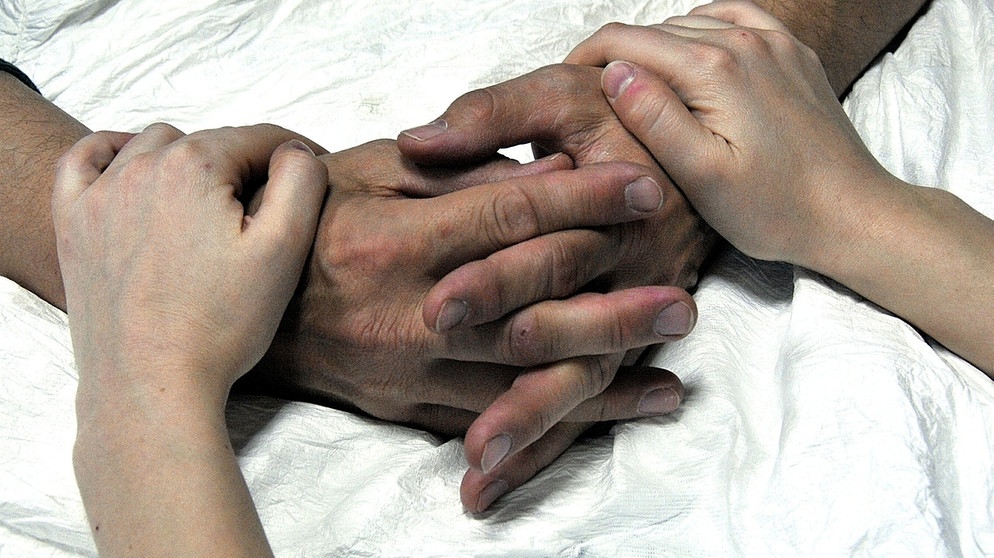 Symbolbild_Wie selbstbestimmt und würdevoll kann Sterben sein (beim Sterben gehaltene Hände) | Bild: picture alliance/dpa/Sami Belloumi