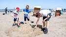 Vater baut mit seinen Kindern eine Sandburg am Strand - Symbolbild | Bild: picture alliance_dpa_Hauke-Christian Dittrich