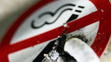 Zigarette wird auf einem Rauchverbotsschild ausgedrückt | Bild: Getty Images