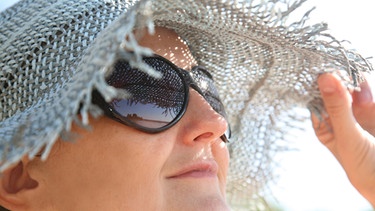 Gesicht einer Frau mit Sonnehut | Bild: picture-alliance/dpa