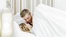 Paar, Mann und Frau, im Bett. Er lächelt sie an. | Bild: picture-alliance/dpa