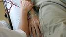 Die Palliativmedizin beinhaltet die Betreuung und Begleitung schwer kranker Menschen in ihrer letzten Lebensphase - im Bild: Hand halten am Krankenbett | Bild: picture-alliance/dpa