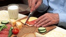 Älterer Mann bereitet sich eine Brotzeit zu | Bild: picture-alliance/dpa