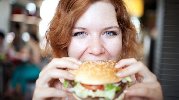 Frau beißt in einen Hamburger | Bild: colourbox.com