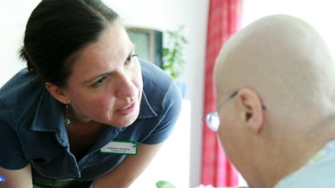 Zuspruch für einen Krebspatienten durch eine Mitarbeiterin einer klinischen Einrichtung | Bild: picture-alliance/dpa