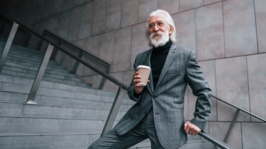 Älterer Mann in Anzug mit Kaffeebecher | Bild: colourbox.com