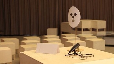 Mikro und Maske auf Tisch. | Bild: Eran Schaerf