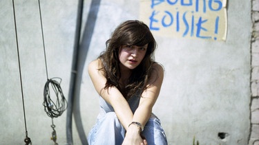 Junge Frau sitzt vor grauer Mauer. Symbolbild für Hörspiel Virginie Despentes: Apokalypse, Baby! | Bild: picture alliance / Taskoparan Erol