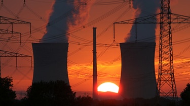 Glühend rot ist der Himmel beim Sonnenuntergang hinter den Kühltürmen des Atomkraftwerks Grafenrheinfeld | Bild: picture-alliance/dpa