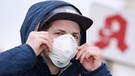 Ein Mann mit einer Schutzmaske vor einer Apotheke | Bild: picture-alliance/dpa