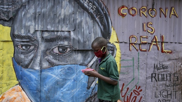 Ein Junge mit Gesichtsschutz vor einem Graffiti in Nairobi | Bild: picture-alliance/dpa