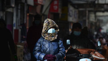 Frau mit Mundschutz an einer Straße in der Stadt Fuyang in China | Bild: picture-alliance/dpa