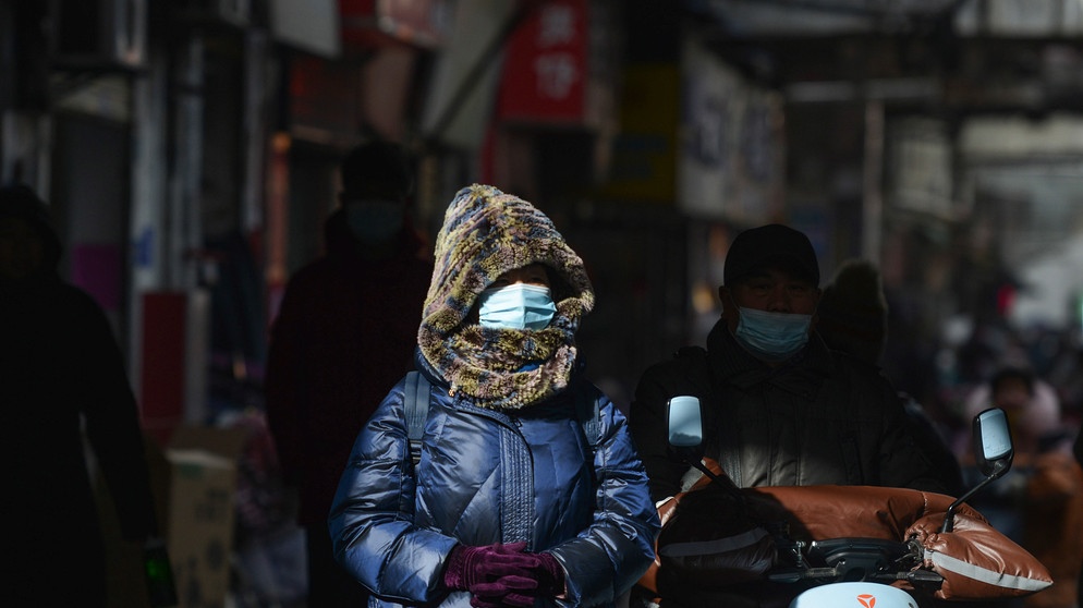 Frau mit Mundschutz an einer Straße in der Stadt Fuyang in China | Bild: picture-alliance/dpa