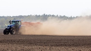 Ein Landwirt pflügt einen Acker in Brandenburg und wirbelt Staub und Sand auf.  | Bild: picture-alliance/dpa