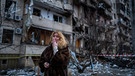 25.02.2022, Ukraine, Kiew: Eine Frau steht vor einem Haus, das bei einem Raketenangriff zerstört wurde.
| Bild: dpa-Bildfunk