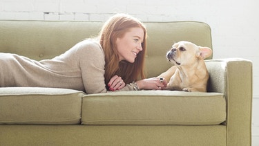 Eine Frau und ihr Hund liegen auf dem Sofa | Bild: picture-alliance/dpa