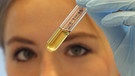 Forscherin betrachtet ein Reagenzglas im Labor | Bild: picture-alliance/dpa