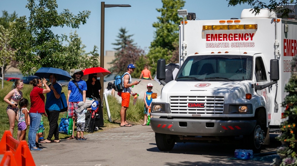 30.06.2021, Kanada, Calgary: Ein Rettungswagen dient als Kühlstation, während die Menschen Schlange stehen, um in einen Wasserpark zu gelangen | Bild: dpa-Bildfunk