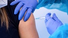 Eine Polizeibeamtin wird mit dem Corona-Impfstoff von AstraZeneca geimpft | Bild: dpa-Bildfunk
