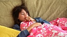 Mädchen liegt zugedeckt auf einem Sofa und hustet | Bild: picture-alliance/dpa