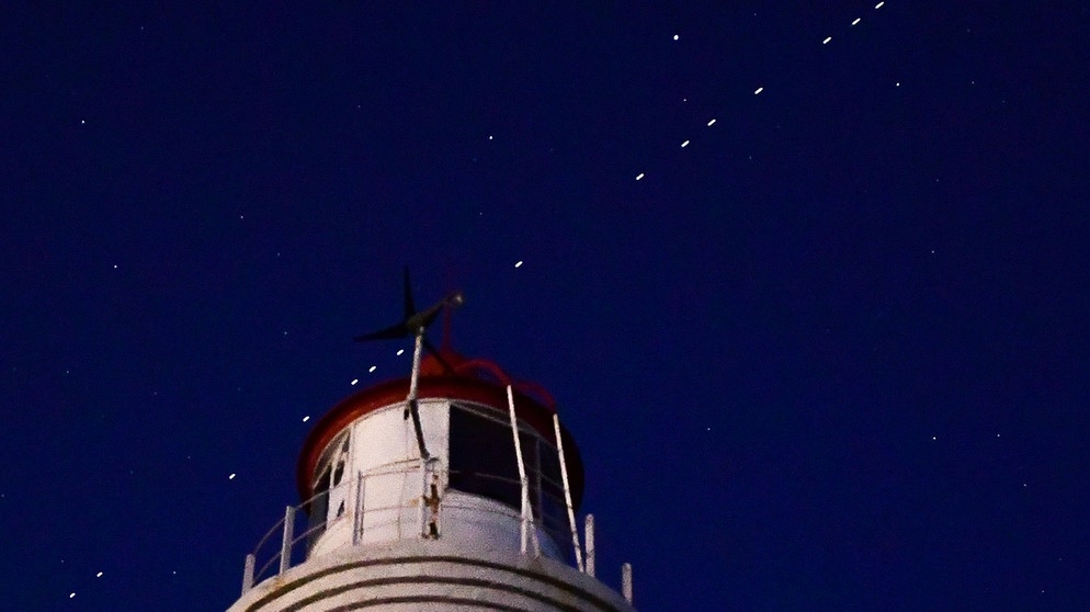 Eine Kette von Starlink-Satelliten am Nachthimmel. | Bild: picture alliance/dpa/TASS | Yuri Smityuk