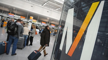 Flugreisende stehen im Terminal 2 des Flughafens in München  | Bild: picture-alliance/dpa