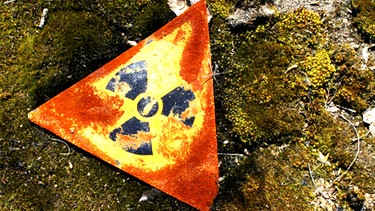 rostiges Atomgefahr-Schild auf moosigem Boden | Bild: picture-alliance/dpa