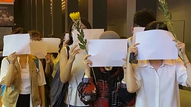 28.11.2022, China, Hongkong: Demonstranten halten leere weiße Papiere vor ihre Gesichter während einer Gedenkveranstaltung für die Opfer nach einem Wohnungsbrand in der nordwestchinesischen Stadt Ürümqi.  | Bild: dpa-Bildfunk/Zen Soo