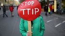 Eine Demonstrationsteilnehmerin mit Plakat nimmt in Hannover auf dem Opernplatz an einer Demonstration gegen das transatlantische Freihandelsabkommen TTIP teil.  | Bild: picture-alliance/dpa