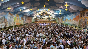 Gäste feiern am 26.09.2012 in München (Bayern) auf dem Oktoberfest im Hacker Festzelt, dem Himmel der Bayern. Die Wiesn gilt als das größte Volksfest der Welt und findet in diesem Jahr vom 22.09. bis 07.10.2012 statt. | Bild: picture-alliance/dpa
