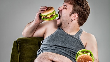  Symbolbild - Maßlosigkeit (Mann isst maßlos Burger)  | Bild: colourbox.com