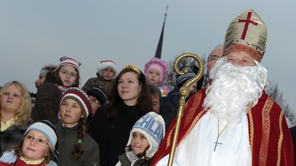 Der Nikolaus steht am 28.11.2010 während der Eröffnung des Weihnachtspostamtes in Himmelstadt (Unterfranken) neben einer Kinderschar.  | Bild: picture-alliance/dpa