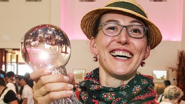 Martina Schwarzmann hält ihren Dialektpreis "Bairische Sprachwurzel" (Straubing, 13.08.2017) | Bild: picture-alliance/dpa/Armin Weigel
