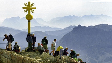 Wanderer aller Nationen am Gipfelkreuz der Zugspitze | Bild: picture-alliance/dpa / Matthias Schrader