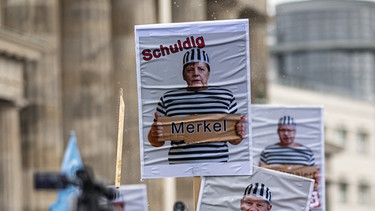 "Merkel schuldig"-Plakat auf einer Demonstration | Bild: picture alliance/dpa/Fabian Sommer 