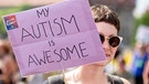 "Mein Autismus ist großartig" steht in englischer Sprache bei der Pride Parade auf dem Plakat einer Teilnehmerin.  | Bild: picture alliance/dpa | Christoph Soeder