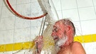 Mann schüttet sich einen Eimer Wasser über den Kopf | Bild: picture-alliance/dpa
