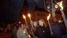 Teilnehmer der nächtlichen Lichterkette vom 6. Dezember 1992 stehen mit Fackeln in der Hand an einer Ampel.  | Bild: picture-alliance/dpa