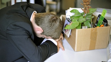 Mann im Anzug lässt erschöpft den Kopf hängen | Bild: picture-alliance/dpa