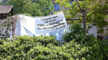 Gegen Pestizideinsatz im Vinschgau: An vielen Häusern in der Gemeinde Mals hängen Transparente gegen den Pestizid-Einsatz. | Bild: BR/Tobias Chmura