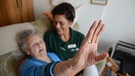 ältere Frau im Pflegebett, daneben Pflegerin | Bild: picture-alliance/dpa