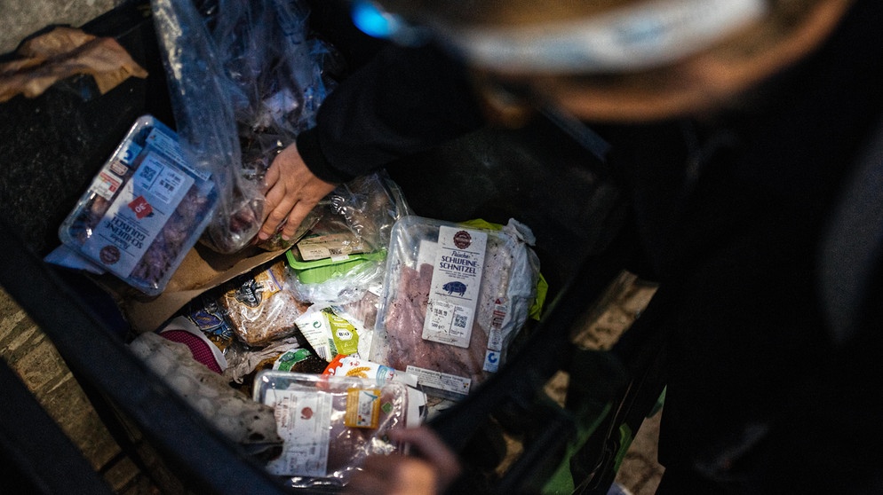 Menschen beim Containern: Sie fischen Lebensmittel aus einer Abfalltonne eines Supermarkts. (Symbolbild) | Bild: BR/Julia Müller