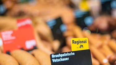 Produkte in einer Wurst-Bedienungstheke in einem Supermarkt, die teilweise Hinweise auf eine regionale Herkunft tragen (Symbolbild) | Bild: picture-alliance/dpa | Frank Hammerschmidt