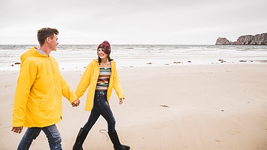 Ein Paar geht am Strand spazieren | Bild: picture alliance / Westend61 | Uwe Umstätter